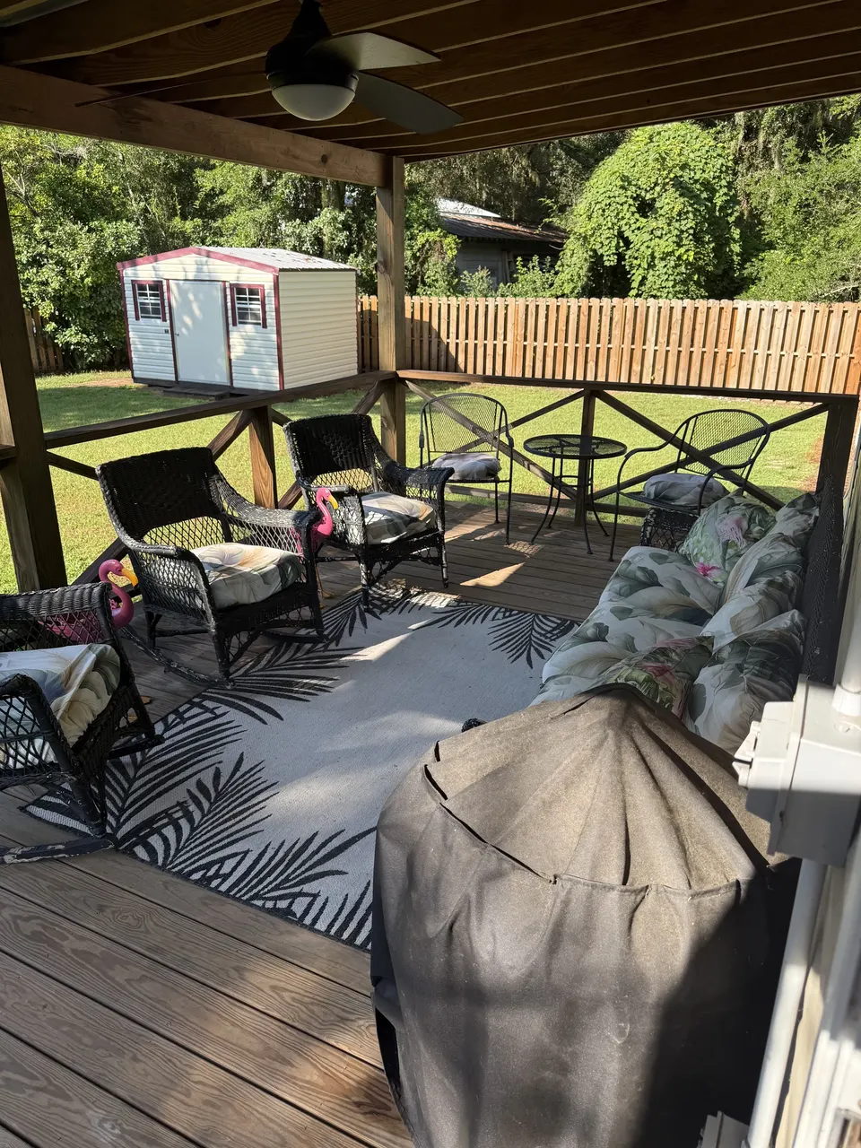 Back deck lounge at Sapelo House with cushioned outdoor seating, grill, and fenced yard.