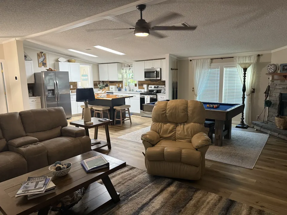 Open living area at Sapelo House showing the lounge seating, kitchen, dining area, and pool table.